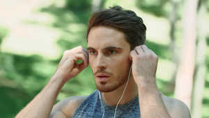 运动男子使用耳机在公园的早晨跑时听音乐9秒视频