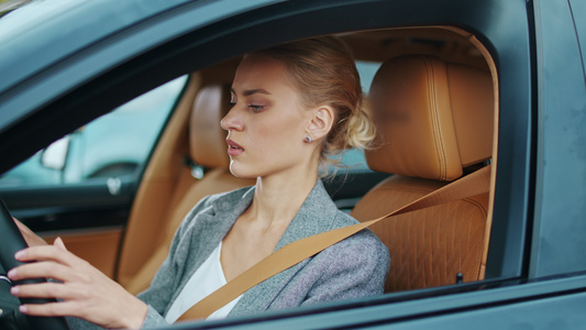 特写白领女性在汽车驾驶座上系安全带开始开车视频