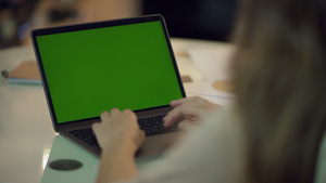 妇女手工打提式电脑键盘,家里有绿色屏幕18秒视频