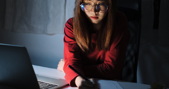 亚洲女性在深夜工作，带着笔记本电脑家庭办公室，看着屏幕显示器不开心工作，自由职业者在家隔离不眠危机，呆在黑暗的视频
