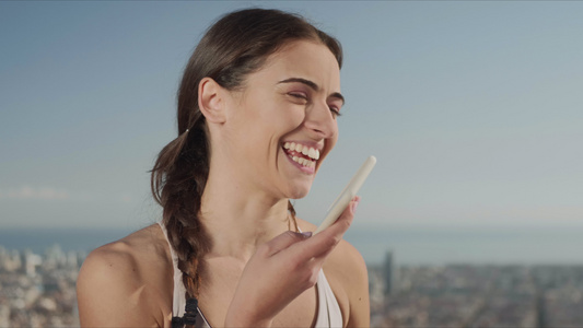 微笑的女士在街上用手机录音语留言的肖像视频