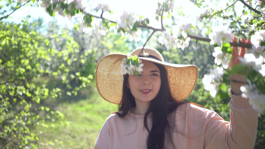 美丽的年轻女子享受着盛开的苹果花春果园视频