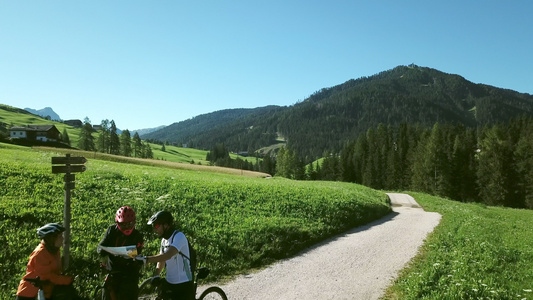 意大利阿尔塔巴迪亚三个骑自行车的人在风景中看地图视频