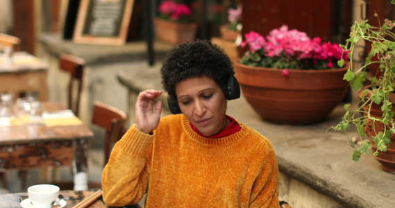 意大利托斯卡纳皮斯托亚户外咖啡馆里戴着耳机的女人视频