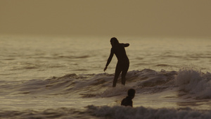 英国德文郡北德文郡日落时在海浪上冲浪的人31秒视频