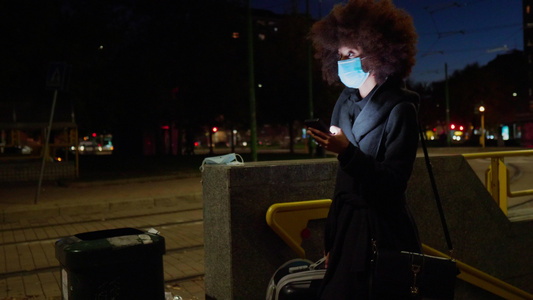 意大利城市夜间使用智能手机戴面罩的妇女视频