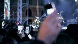 一群人观看新年庆祝晚会并用智能手机录制视频和拍照10秒视频