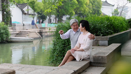 4k老年夫妇坐在河边看风景聊天视频