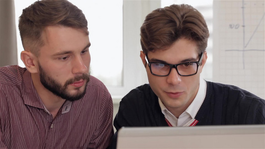 男人在眼镜里给男同事解释笔记本电脑上的东西视频