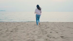 幸福的女子在热带海滩享受暑假赤脚奔向海洋双臂张开15秒视频