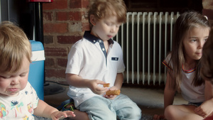 三个年轻的男孩和女孩坐在地板上吃炸薯条6秒视频