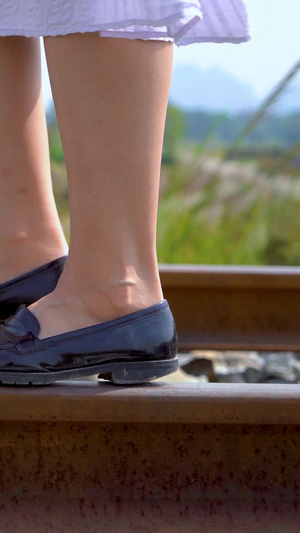穿着裙子漫步在铁轨上的女孩脚步特写穿裙子的女孩26秒视频