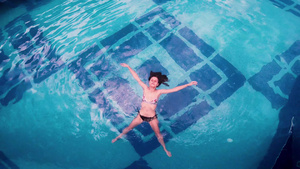 比基尼女孩躺在游泳池水面上19秒视频