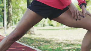 身体健康的女孩在公园里伸膝膝盖,为跑跑起来而热身运动11秒视频