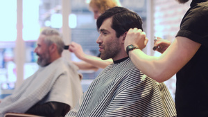 发型师梳理他的顾客的头发10秒视频
