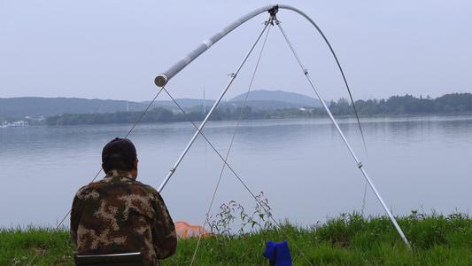 湖边垂钓的钓鱼爱好者4k休闲娱乐素材视频
