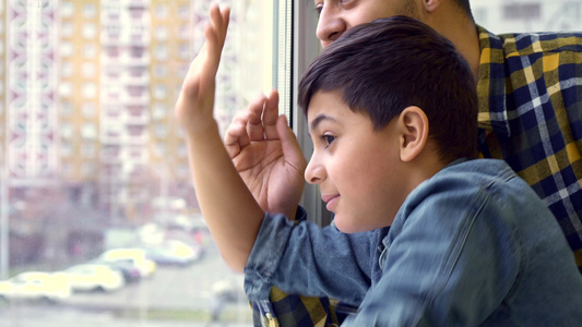 男孩儿和他父亲,从窗外挥手视频