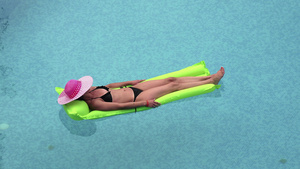 性感女孩漂浮在海中或游泳池的床垫上14秒视频