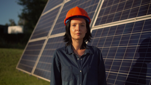 妇女佩戴橙色头盔,太阳能电池板视频