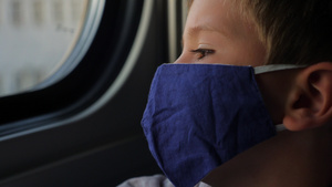 戴着口罩看着火车窗的年轻男孩10秒视频