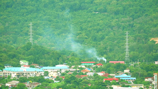 山区和山丘上村庄中燃烧城市烟雾的草地视频