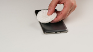 两只女性手握着一个黑色智能手机和一个棉花垫16秒视频