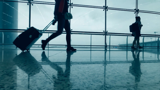 4K实拍机场落地窗背着背包拖着行李走过的旅客视频