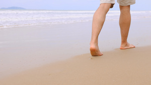 走在沙滩上青年男性的腿部特写15秒视频