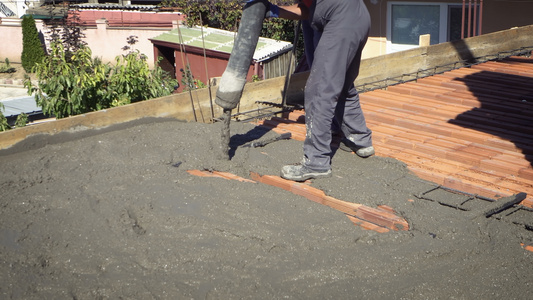 混凝土工人正在用钢筋加固将倒液化混凝土压平,以形成坚固的地板板视频