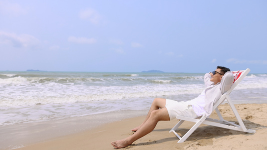 沙滩椅上享受假期的男性青年视频