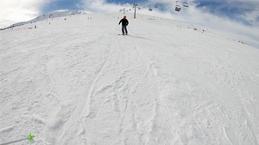 阳光明媚的日子里，保加利亚山区的高山滑雪者在相机后面的斜坡上滑雪，慢动作视频