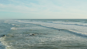 海洋冲浪器下午光亮天空晴朗时有白泡沫波空中高角前方圆圆圆4k32秒视频