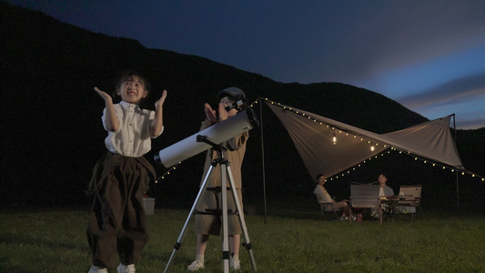 夜晚野外露营小朋友用望远镜看星空视频