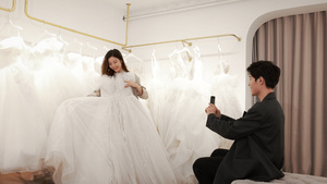 年轻情侣婚纱店拍照挑选婚纱20秒视频