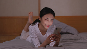 女孩卧室床上轻松玩手机聊天44秒视频