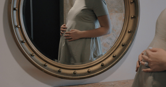 孕妇看着镜子抚摸肚子视频