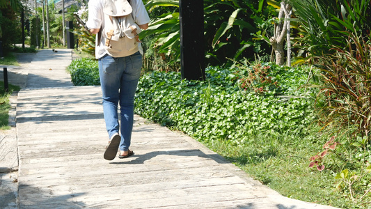 亚洲女游客背着背包走在人行道上去海边视频