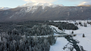4k航拍冬天的森林雪山河流25秒视频