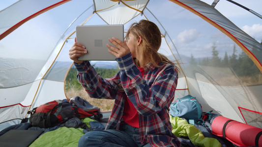 女生在帐篷里看ipad视频