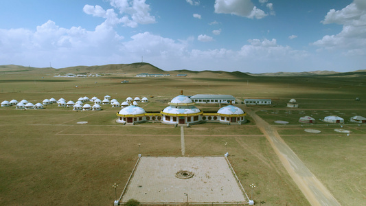 5k航拍蓝天下草原上的巨型蒙古包视频