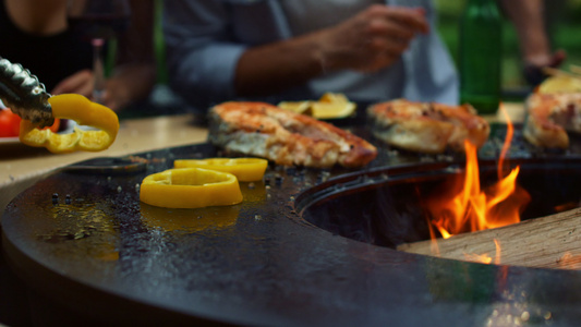 在外面做饭的面目全非的人厨师把洋葱和胡椒放在烤架上视频