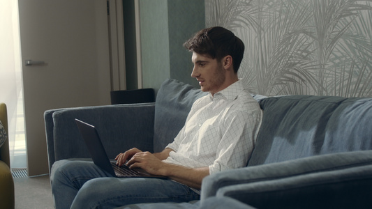 在酒店房间用笔记本电脑打笑的男人帅哥在室内聊天视频