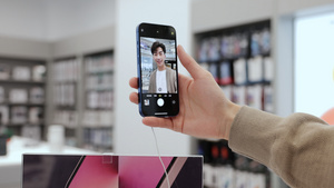 青年男性数码店体验手机自拍功能11秒视频