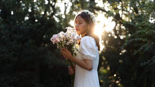 女生手捧鲜花享受自然与落日阳光视频