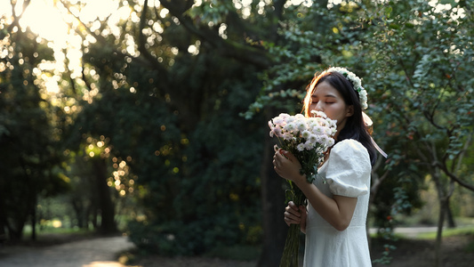 女生手捧鲜花享受自然气息视频