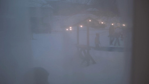 寒冬傍晚黄昏隔着窗帘拍摄户外家庭亲子雪地曲棍球游戏13秒视频