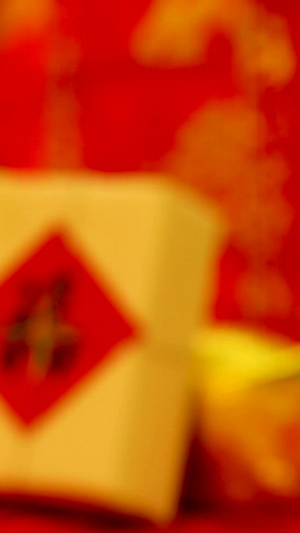 红色喜庆背景前悬挂红包福字礼盒实拍虚焦静物视频传统文化5秒视频