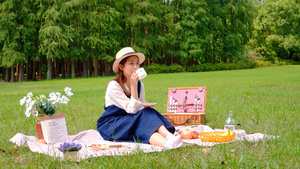 草地上野餐喝咖啡的女青年7秒视频