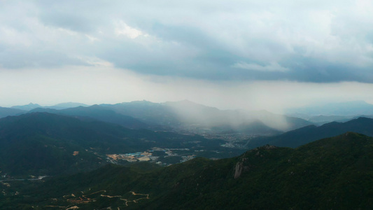 航拍山顶上远处下雨视频