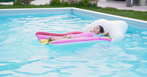 8K夏日可爱小女孩躺在泳池里的漂浮床上10秒视频